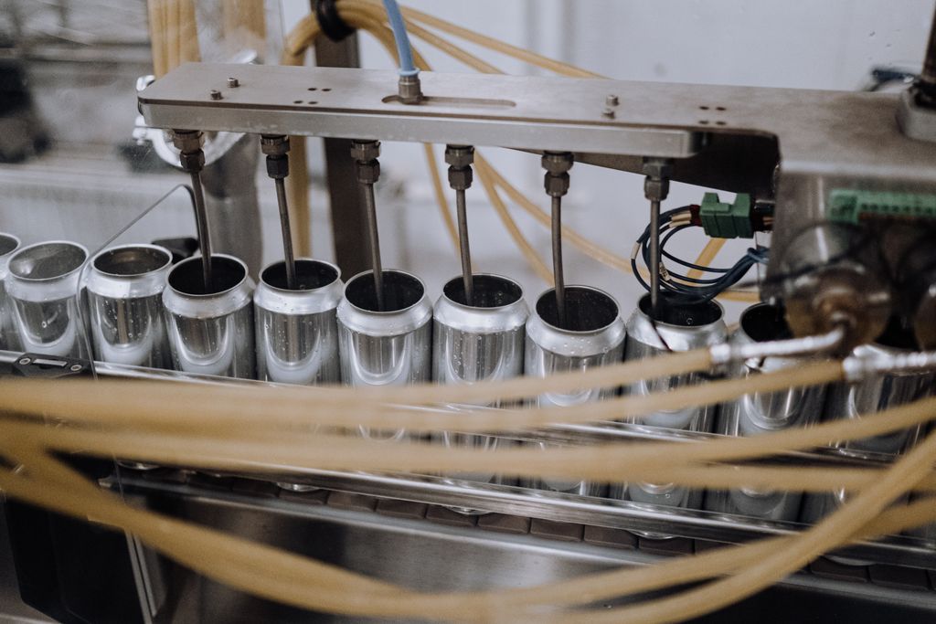 Close-up of automated machinery on a beverage can filling production line indoors. sqf certification